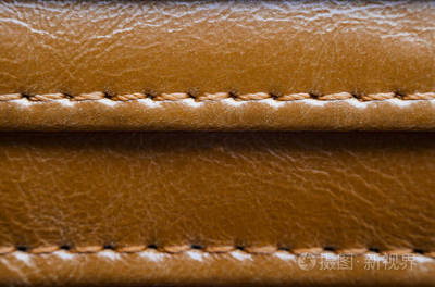 质地的褐色皮革与针。皮革服装特写的元素。皮革制品接缝